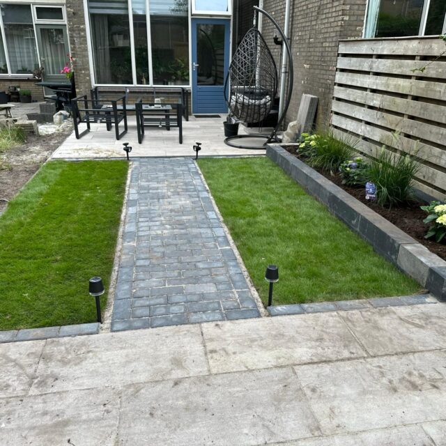 Een achtertuin met comfortabele tuinmeubelen en groene planten, perfect om te ontspannen.